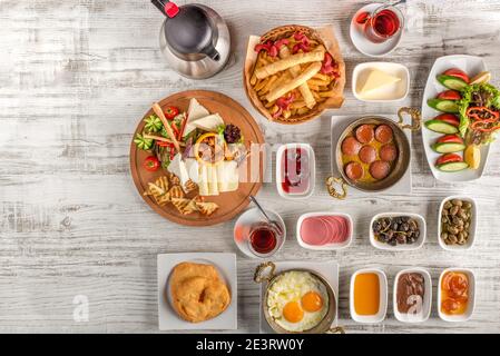 Petit-déjeuner turc traditionnel servi avec du thé turc traditionnel sur une table en bois. Banque D'Images