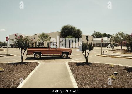 Pick-up Red Classic d'époque traversant une intersection dans une petite ville Banque D'Images