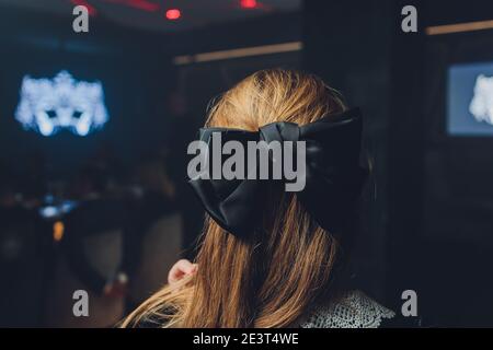 Tête de fille avec un gros noeud noir sur sa tête Banque D'Images