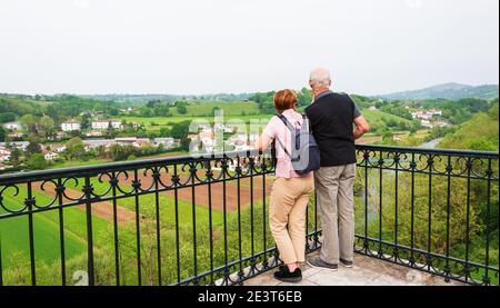 Couple senior (vue arrière; non reconnaissable) admirant la vue sur la vallée de la Nive depuis la promenade de Cambo-les-bains (charmante ville thermale). Printemps. Français Banque D'Images