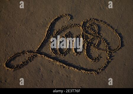 L'amour écrit sur le sable, l'écriture sur le sable. Arrière-plan de la plage. Vue de dessus. Photo de haute qualité Banque D'Images