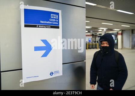 Londres, Royaume-Uni. 20 janvier 2021. Un homme passant par un panneau, avec des indications pour le Centre de vaccination NHS récemment ouvert à Wembley.le site est situé près du stade Wembley, dans le Centre du Bureau Olympique. Il s'agit de l'un des 25 nouveaux sites qui ouvriront à Londres cette semaine. Crédit : SOPA Images Limited/Alamy Live News Banque D'Images