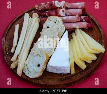 salami, fromage, mortadelle, jambon cru sur une planche de bois et pain Banque D'Images