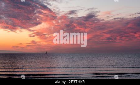 Beau coucher de soleil. Rose, violet, doré, orange, bleu couleurs sur la mer. Ciel plein de nombreuses couleurs. Bateau dans l'eau. Banque D'Images