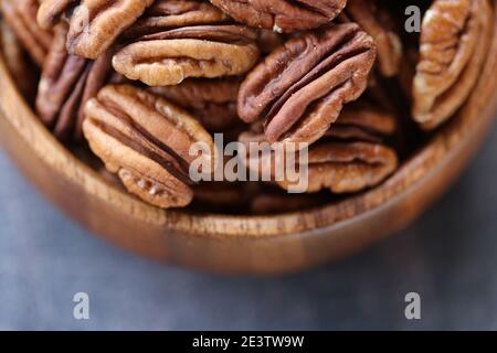 Noix de pécan en gros plan dans une tasse ronde en bois .noix et graines. .graisses saines.Heap shellichte noix de noix closeup.keto diète.savoureux aliment bio cru Banque D'Images