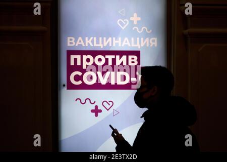 Moscou, Russie. Le 20 janvier, 2021 citoyens portant un masque facial restent en file d'attente devant une unité mobile de vaccination COVID-19 au magasin GUM du centre de Moscou, en Russie. Depuis janvier 18, la Russie a commencé la vaccination de masse contre le nouveau coronavirus COVID-19 avec le vaccin Spoutnik V. La bannière est intitulée 'vaccin COVID-19' Banque D'Images