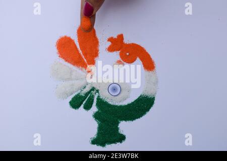 Femme faisant des rangoli design tricolore safran blanc et Vert à l'occasion de la célébration de la veille de la république indienne Banque D'Images