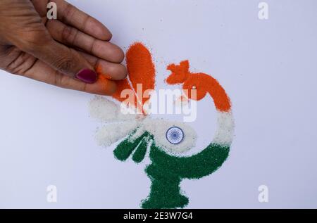 Femme faisant des rangoli design tricolore safran blanc et Vert à l'occasion de la célébration de la veille de la république indienne Banque D'Images