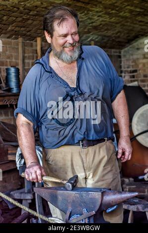 Le forgeron Ralph Oalmann sourit alors qu'il parle avec les touristes tout en travaillant dans son magasin à fort gaines, le 5 août 2017, à Dauphin Island, Alabama. Banque D'Images