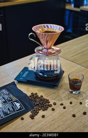 Gros plan de la mouture de café dans le filtre papier sur le numérique balance à café tout en faisant un café goutte à goutte Banque D'Images