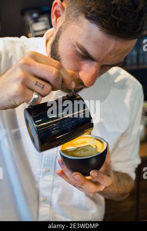 Yuri Marschall, champion d'art latte d'Allemagne, verse du lait chaud dans une tasse de café pour faire du latte Banque D'Images