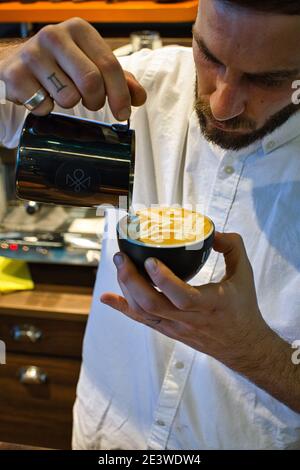 Yuri Marschall, champion d'art latte d'Allemagne, verse du lait chaud dans une tasse de café pour faire du latte Banque D'Images