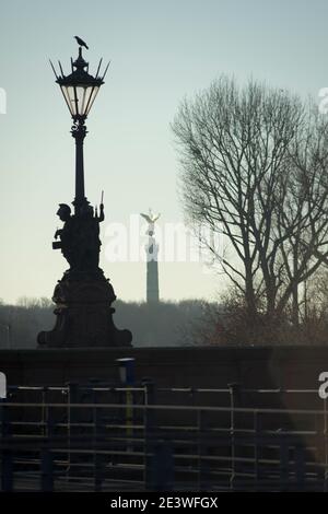 Un corbeau se trouve sur un lampadaire du Moltkebrücke à Berlin-Tiergarten. En arrière-plan vous pouvez voir la colonne victoire, Allemagne 2020. Banque D'Images