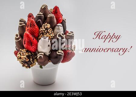 Carte de vœux de joyeux anniversaire avec inscriptions rouges ; BOUQUET de fleurs comestibles, arrangement de fraises enrobées de chocolat isolées sur le backgrou blanc Banque D'Images