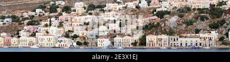 Une vue pittoresque de la mer au village de l'île grecque SYMI. Maisons panoramiques en bord de mer aux couleurs variées et à l'architecture néo-classique authentique. Banque D'Images