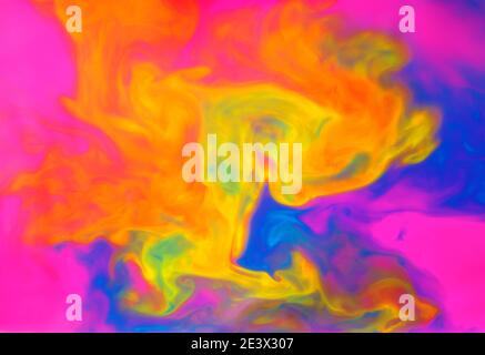 Liquides colorés mélangés dans un fluide créant un arrière-plan abstrait coloré Banque D'Images