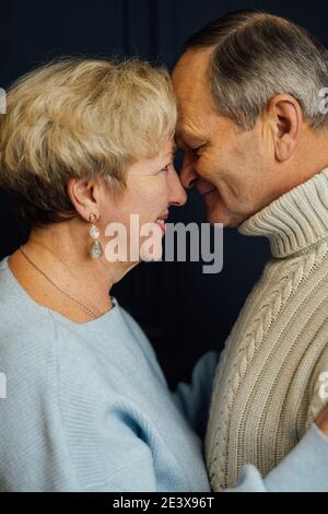 portrait en gros plan de la femme et du mari d'un vieux couple souriant. Arrière-plan bleu foncé. Heureux amoureux à la retraite. Arrêtez l'âgisme. Banque D'Images