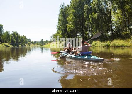 Un couple d'hommes et de femmes font du kayak sur la rivière en été. Loisirs actifs, voyages en famille, aventure extrême, sports et environnement domestique touris Banque D'Images