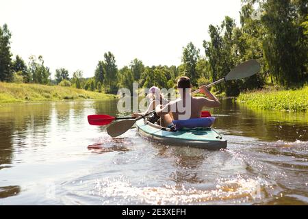 Un couple d'hommes et de femmes font du kayak sur la rivière en été. Loisirs actifs, voyages en famille, aventure extrême, sports et environnement domestique touris Banque D'Images