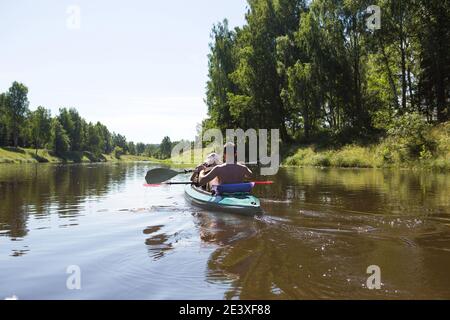 Un couple d'hommes et de femmes font du kayak sur la rivière en été. Loisirs actifs, voyages en famille, aventure extrême, sports et environnement domestique touris Banque D'Images