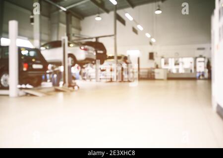 Service de réparation automobile dans un environnement industriel et flou artistique. Voitures sur les ascenseurs, zone de service de transport. Copier l'espace Banque D'Images