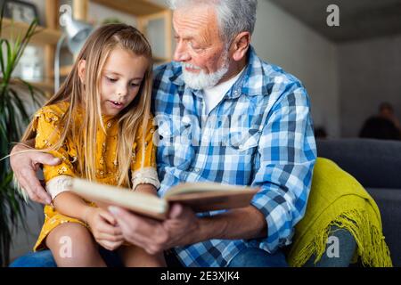 Grand-père barbu et son petit-fils ont du plaisir de lire un livre ensemble Banque D'Images