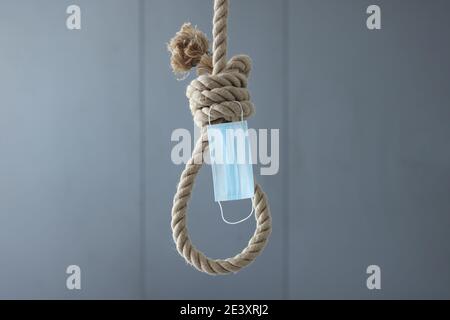 Boucle de corde de suicide et masque de protection suspendu au plafond Banque D'Images