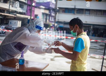 Bangkok, Thaïlande. 1er janvier 2000. Un responsable de la santé effectue un test à base de salive sur une tasse chez un travailleur migrant au cours d'un test Covid-19 à base de salive à l'Organisation de commercialisation du poisson de Bangkok pendant un dépistage et un test Covid-19 à la suite d'une nouvelle éclosion en Thaïlande.le ministère de la Santé de la Thaïlande a enregistré un total de 12,795 infections, 71 décès et 9,842 se sont rétablis depuis le début de l'éclosion. Crédit: Adisorn Chabsungnoen/SOPA Images/ZUMA Wire/Alay Live News Banque D'Images