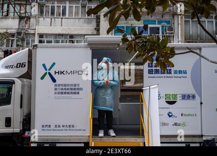 Un professionnel de la santé vêtu d'un équipement de protection individuelle (EPI) attend à l'intérieur d'une fourgonnette mobile Covid-19 à Hong Kong. Plusieurs véhicules d'essai mobiles sont en service à Hong Kong afin de fournir gratuitement aux résidents des services d'essai Covid-19 alors que le coronavirus Covid-19 continue de se propager dans la ville. Banque D'Images