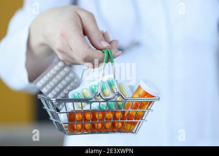 Médecin tenant un petit panier d'épicerie avec des médicaments en gros plan Banque D'Images