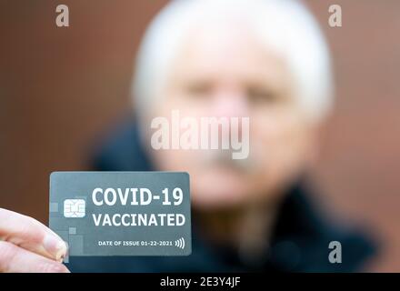 Homme âgé présentant un certificat de vaccination, qui indique une vaccination contre le covid-19. Banque D'Images
