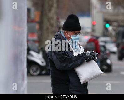 Paris, France. 21 janvier 2021. Un homme portant un masque et des gants en plastique attend une croix à Paris, France, le 21 janvier 2021. Le nombre de cas confirmés de coronavirus en France a atteint un sommet de deux mois à 26,784, ont indiqué les autorités sanitaires mercredi. Selon les données officielles, un chiffre quotidien plus élevé, à 28,393, a été enregistré le 18 novembre 2020. Credit: Gao Jing/Xinhua/Alamy Live News Banque D'Images