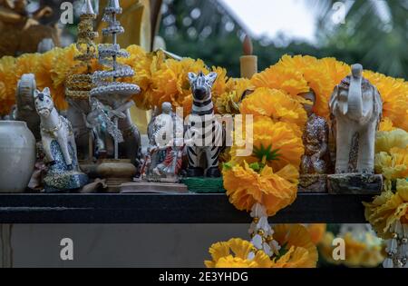 Poupées dansantes thaïlandaises, poupées Zebra et guirlandes florales marigold dans le Thao Maha Phrom Shrineis. Mise au point sélective. Banque D'Images