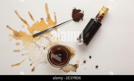 Concept café avec café dans une tasse, grains de café et sirop de crème irlandais isolés sur fond blanc, vue du dessus Banque D'Images