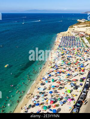 Vue aérienne de la plage bondée de Tropea pleine de vacanciers pendant l'été, Calabre, Italie Banque D'Images