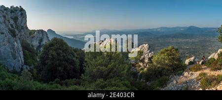 Baunei, Sardaigne, Italie, 17 septembre 2020: Jeune couple heureux prenant le petit déjeuner au point de vue de Baunei avec paysage vert panoramique d'arbres Banque D'Images