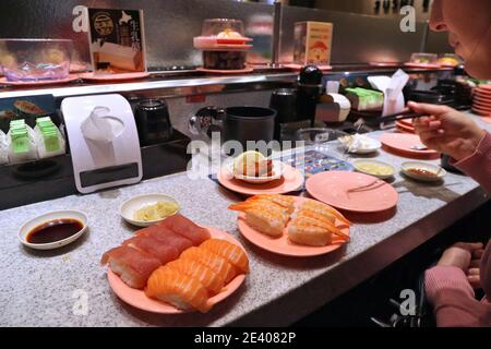 KEELUNG, TAÏWAN - 23 NOVEMBRE 2018 : manger des sushis dans un restaurant de sushis à tapis roulant de Keelung, Taïwan. Banque D'Images