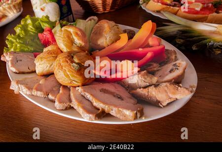 Assiette avec de délicieux en-cas sur une table dans un café. Tapas, hors-d'œuvre à la table du buffet dans un restaurant. Hamburgers, viande farcie cuite au four avec épices, tranche Banque D'Images