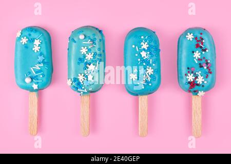 Glace savoureuse et rafraîchissante sur bâtonnets. Glaces à la menthe bleue sur fond rose pastel. Concept d'été minimal. Pose à plat. Banque D'Images