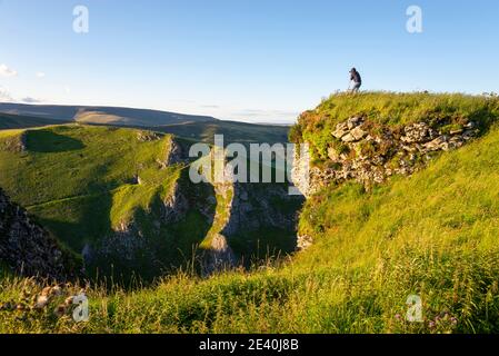 Un photographe à Winnats passe près de Castleton dans le Peak District, Derbyshire, Angleterre, lors d'une belle soirée d'été. Banque D'Images
