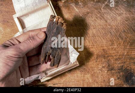 Cliché sélectif de la main de l'homme tenant des racines de ginseng sèches Banque D'Images