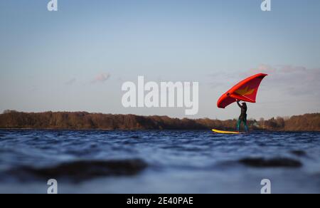 21 janvier 2021, Schleswig-Holstein, Neumünster: Une surfeuse est en route avec sa wingsurf sur l'Einfelder See. Photo: Christian Charisius/dpa Banque D'Images