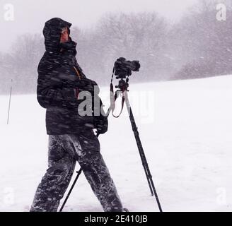 A photographer working, taking photos during a blizzard on the Plains of Abraham, Quebec City, Banque D'Images