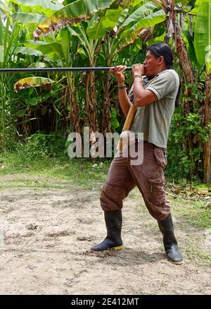 Homme utilisant un pistolet à air; indigène, chasse; compétence; arme longue, bottes en caoutchouc, Amérique du Sud, forêt tropicale amazonienne, Equateur, MR Banque D'Images