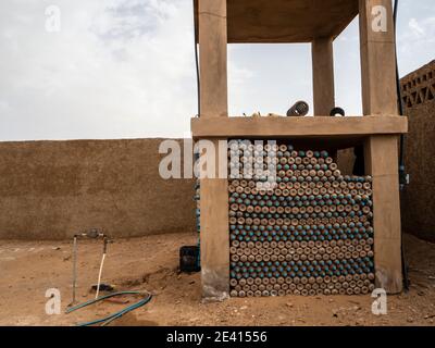 Réutilisation de conteneurs d'eau en plastique pour la construction de murs dans le Désert du Sahara Banque D'Images