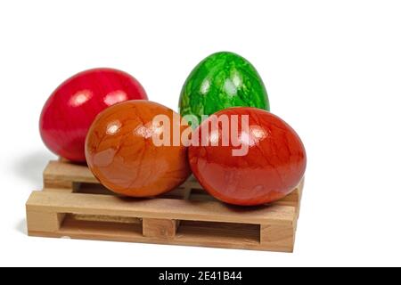 Oeufs de Pâques colorés sur une palette en bois contre un blanc arrière-plan Banque D'Images
