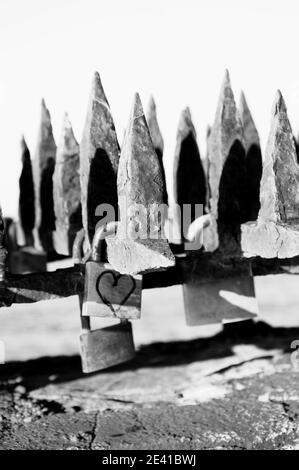 Écluses d'amour aux coeurs attachées à la clôture de feu antique à Collioure (France). Vieux concept d'amour. Promesse éternelle d'amour. Noir blanc Banque D'Images