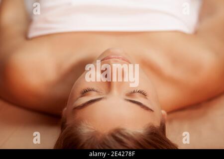 Vue de dessus gros plan d'une jeune femme magnifique avec une peau impeccable et sans imperfections, allongé sur une table de massage au centre thermal. Belle femme se reposant après s Banque D'Images