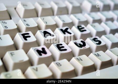 Détail d'un clavier d'ordinateur avec l'écriture de fausses nouvelles avec un marqueur Banque D'Images