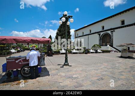 Vendeur traditionnel de crème glacée avec son chariot d'époque sur la place principale (Zócalo) le long de l'ex couvent de San Francisco de Asís à Zacatlán, Mexique. Banque D'Images